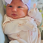 Avyanna is registered to the contest to win money with this photo: baby, blanket, bow, child, cozy, curious_expression, cute, face, headband, human, indoors, infant, lying_down, newborn, onesie, patterned_clothing, pink_clothing, portrait, sleepwear, soft_texture