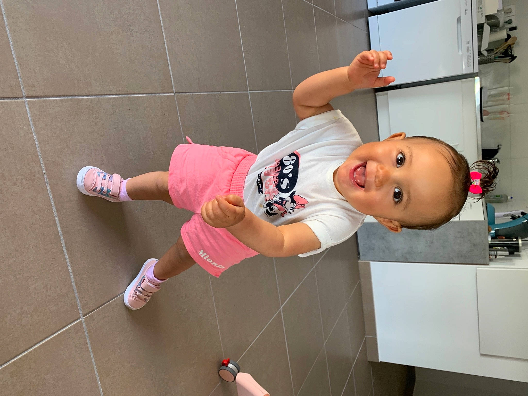 Tya participe au concours pour gagner de l'argent avec cette photo : child, flooring, fun, happy, home_appliance, human_leg, joy, knee, machine, magenta, major_appliance, person, refrigerator, room, sandal, shelf, shorts, smile, sportswear, t_shirt