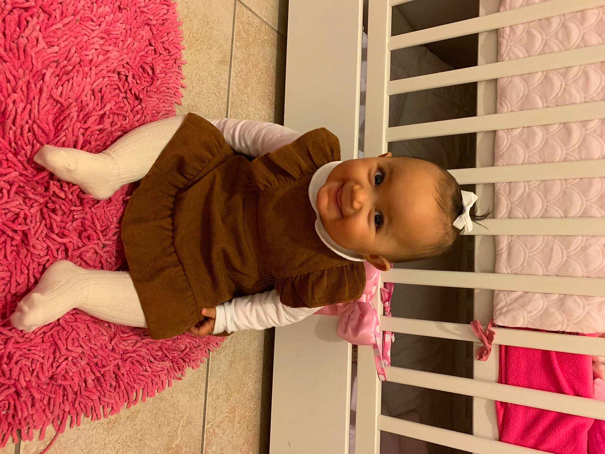 Tya a rejoint le concours — aidez-le/la à gagner de superbes lots ! baby, baby_safety, baby_toddler_clothing, building, child, flooring, happy, joy, linens, magenta, nursery, person, pink, product, red, skin, sleeve, smile, textile, toddler