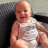 baby, smiling, sitting, cushion, wicker_chair, tank_top, indoor, happy, child, infant, cute, pattern, furniture, skin, person, portrait, young, plump, hand, foot