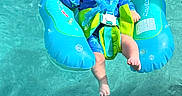 Hansel joined the competition — help win amazing prizes! adult_hand, baby, blue, body, child, floatation_device, floating, green, infant, legs, outdoor, person, pool, recreation, safety, summer, sunlight, swimming, water, water_sport