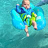 Hansel joined the competition — help win amazing prizes! baby, child, pool, water, floatation_device, blue, green, infant, summer, safety, swimming, person, outdoor, water_sport, recreation, floating, adult_hand, sunlight, legs, body