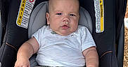 Hansel joined the competition — help win amazing prizes! baby, infant, car_seat, pacifier, white_shirt, checkered_shorts, outdoor, child, seat_belt, black_car_seat, cute, plump, foot, hand, expression, comfort, safety, warning_labels, sunlight, ground