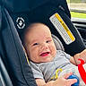baby, car_seat, smiling, child, toy, clothing, window, car_interior, seatbelt, infant, happy, portrait, person, hand, face, sitting, daylight, seat, cute, child_care