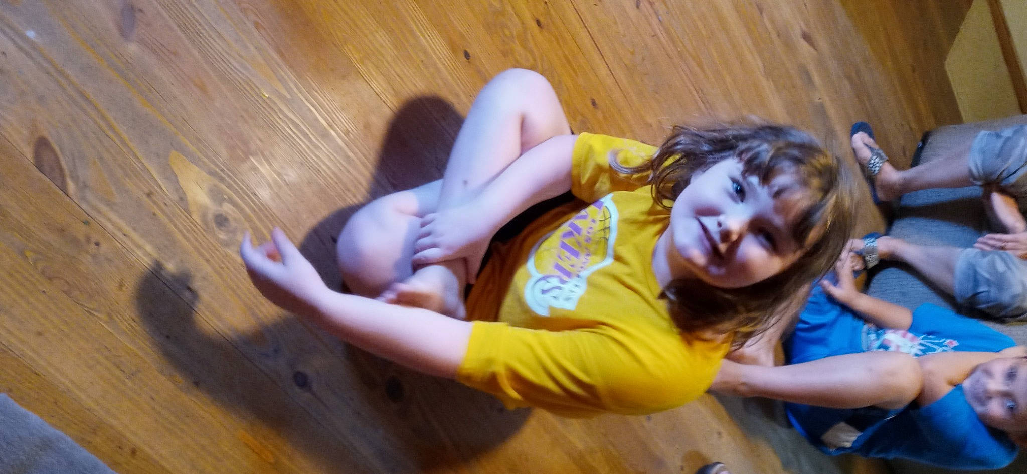 Rachel is registered to the contest to win money with this photo: abdomen, arm, child, elbow, entertainment, finger, fun, hand, happy, hardwood, headwear, human_leg, joy, knee, leisure, person, sitting, smile, sportswear, t_shirt