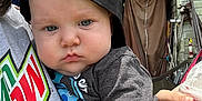 Theodore joined the competition — help win amazing prizes! baby, child, face, cap, black_cap, tshirt, hand, person, outdoor, backyard, shed, greenery, drink, cup, holding, expression, casual_clothing, summer, daylight, portrait
