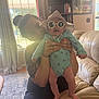 Nova joined the competition — help win amazing prizes! baby, woman, indoor, sunlight, sunglasses, hat, tattoo, smile, holding, furniture, window, curtains, couch, person, child, legs, blue_clothing, table, carpet, home