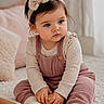 toddler, child, baby, headband, bow, overalls, long_sleeve, knitwear, wooden_blocks, carpet, soft_lighting, indoor, playtime, cute, pink, focus, hands, sitting, cozy, cushion