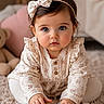 baby, child, infant, girl, blue_eyes, headband, bow, floral_pattern, long_sleeves, wooden_blocks, carpet, indoor, cute, playing, hands, sitting, portrait, soft_lighting, candid, adorable