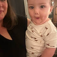 Antonio joined the competition — help win amazing prizes! toddler, child, adult, person, indoor, clothing, white_outfit, pattern, horse_print, holding, surprised_expression, face, portrait, human, black_clothing, woman, blurred, casual, family, home