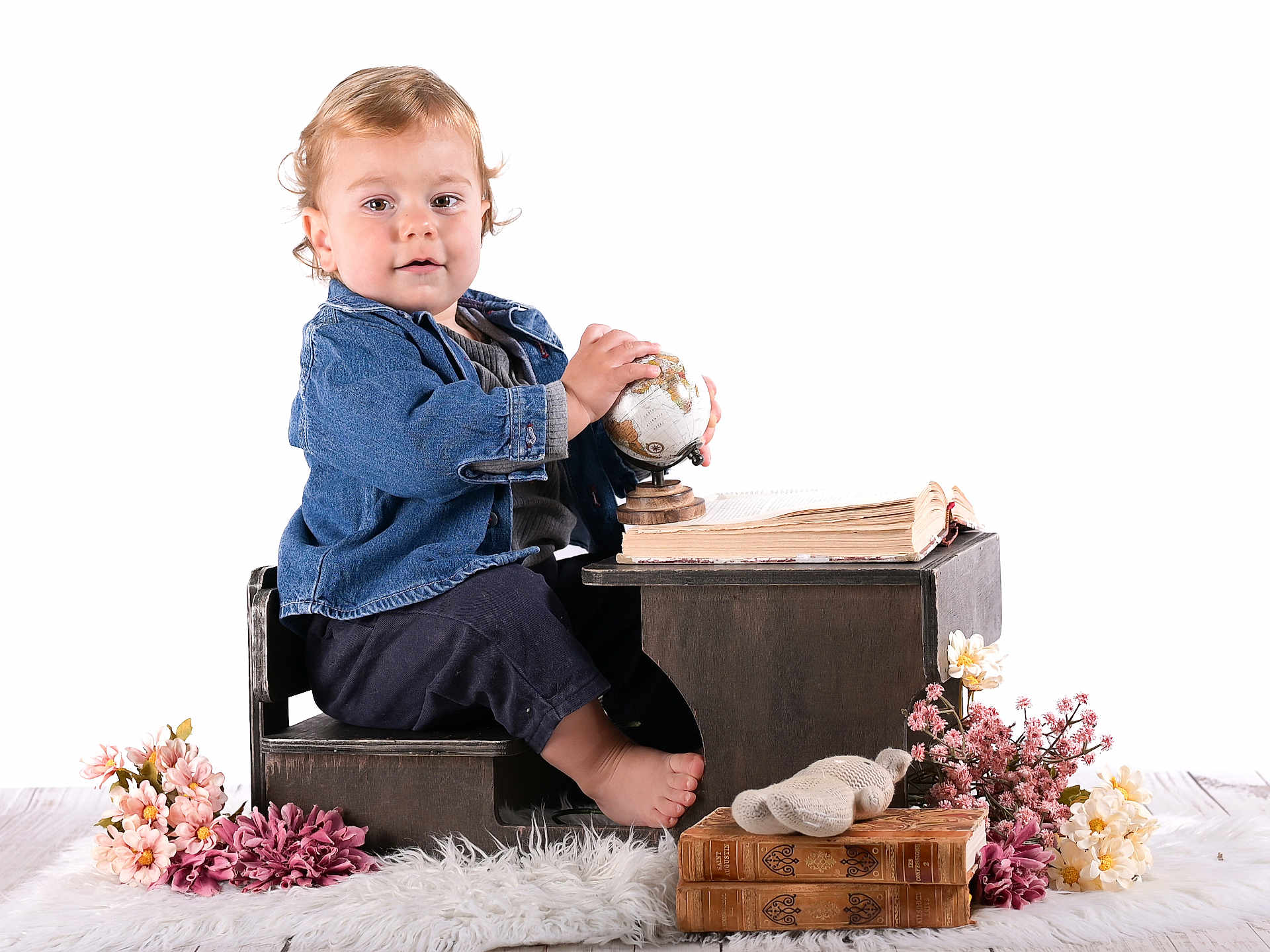 Alessio a rejoint le concours — aidez-le/la à gagner de superbes lots ! toddler, child, barefoot, denim_jacket, small_globe, wooden_chair, wooden_desk, open_book, old_books, flowers, plush_toy, white_rug, indoor, portrait, curious, baby, sitting, cozy, vintage_style, cute