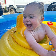 Alessio a rejoint le concours — aidez-le/la à gagner de superbes lots ! baby, child, smiling, laughing, inflatable_pool, yellow_float, water, wet_hair, outdoor, summer, toy, van, vehicle, sunlight, happy, skin, arm, head, face, play