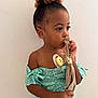 Elayana a rejoint le concours — aidez-le/la à gagner de superbes lots ! bun, child, cloth, curly_hair, cute, earrings, expression, fashion, floral_pattern, girl, holding, indoor, off_shoulder_dress, pacifier, portrait, skin, standing, thoughtful, turquoise_dress, young_child