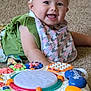 baby, infant, headband, bib, toy, toy_piano, carpet, smiling, happy, child, colorful, play, music, indoor, cute, person, portrait, closeup, furniture, floor