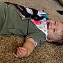 baby, child, smiling, carpet, green_outfit, bib, soft_book, lying_down, infant, indoors, cute, happy, skin, person, head, hand, toy, floor, expression, closeup
