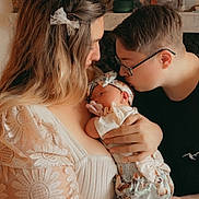 Brixlee is registered to the contest to win money with this photo: woman, baby, newborn, child, glasses, kiss, love, family, tenderness, headband, pacifier, floral, lace, clothing, portrait, indoor, warm_light, decor, person, holding