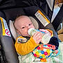 baby, blanket, bottle, car_seat, child, clothing, colorful, comfort, cute, face, feeding, hand, head, indoor, infant, pacifier, portrait, seatbelt, toy, warning_label