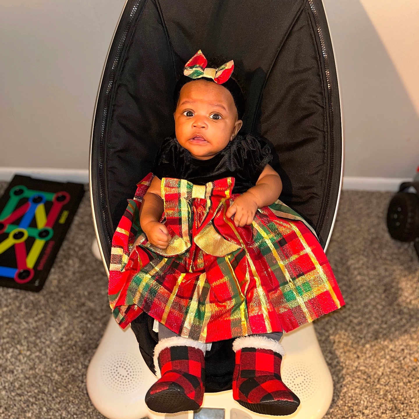 Aria is registered to the contest to win money with this photo: baby, chair, clothing, costume, face, footwear, furniture, head, homedecor, hosiery, indoors, person, photography, portrait, shoe, sitting, skirt, sock, tartan, toy
