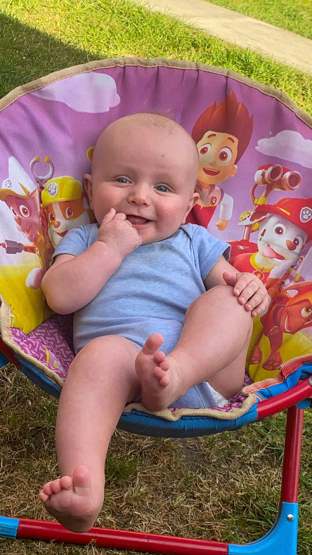 Tommy joined the competition — help win amazing prizes! baby, child, outdoor, grass, chair, paw_patrol, blue_onesie, smiling, happy, foot, hand, head, face, toy_chair, colorful, sunlight, nature, cute, infant, playful