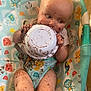 Tommy is registered to the contest to win money with this photo: animal_print, baby, child, chocolate, colorful, curious, cute, eating, face, floor, food, hands, happy, highchair, indoor, legs, messy, pattern, playful, seat