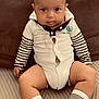 Naël participe au concours pour gagner de l'argent avec cette photo : baby, carpet, child, comfortable, couch, cozy, cushion, cute, home, indoor, infant, person, portrait, sitting, smiling, striped_sleeves, striped_socks, tongue_out, white_outfit, young_child