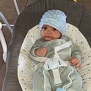 Naël a rejoint le concours — aidez-le/la à gagner de superbes lots ! baby, baby_boy, baby_clothing, baby_rocker, baby_seat, blue_booties, child, comfort, cushion, face, feet, hands, hat, indoor, infant, onesie, seated, small_person, straps, tile_floor