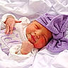 newborn, baby, sleeping, purple_bow, blanket, white_clothing, closeup, infant, soft_texture, cute, peaceful, resting, wrapped, portrait, child, toddler, headwear, cozy, pink_cheeks, indoors