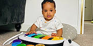 Kayce is registered to the contest to win money with this photo: bright, carpet, child, colorful, cushion, cute, floor, furniture, home, indoor, music, person, piano, playtime, short_hair, smiling, sofa, toddler, toy, white_wall