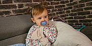 Lina a rejoint le concours — aidez-le/la à gagner de superbes lots ! toddler, child, pacifier, stuffed_animal, pigtails, couch, pillow, blanket, brick_wall, tablet, charging_cable, indoor, casual_clothing, long_sleeve_shirt, pants, socks, cute, seated, toy, home