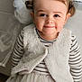 Lina participe au concours pour gagner de l'argent avec cette photo : toddler, child, smile, face, vest, striped_shirt, tulle_skirt, pigtails, hair, cute, portrait, indoors, soft_lighting, cozy_clothing, happy, young_child, person, baby, fashion, closeup