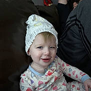 Eliza joined the competition — help win amazing prizes! toddler, child, pajamas, diaper, couch, smile, face, person, indoor, relaxing, adult, clothing, heart_pattern, baby, seated, casual, funny_hat, home, cozy, playful