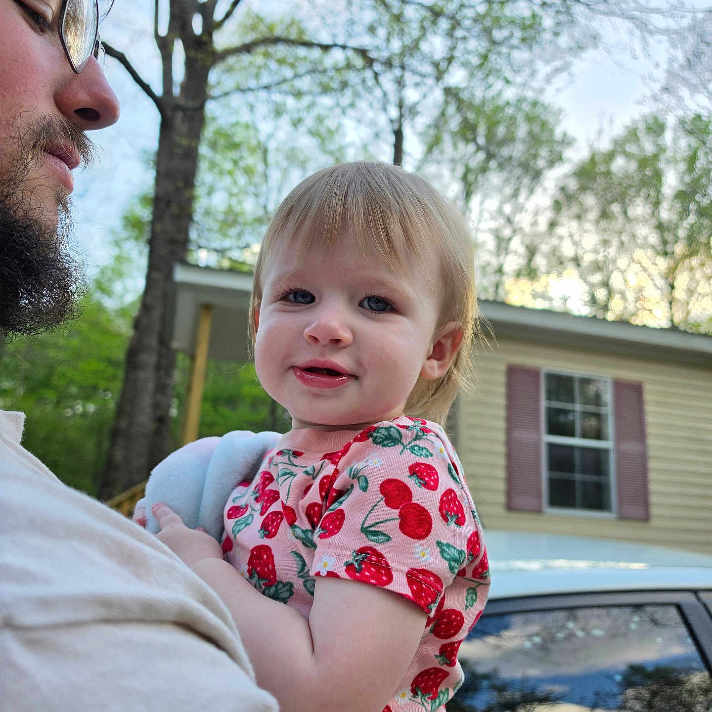 Eliza is registered to the contest to win money with this photo: toddler, child, adult, beard, glasses, holding, outdoor, house, window, trees, greenery, daylight, person, smile, shirt, pattern, strawberry, nature, car, portrait