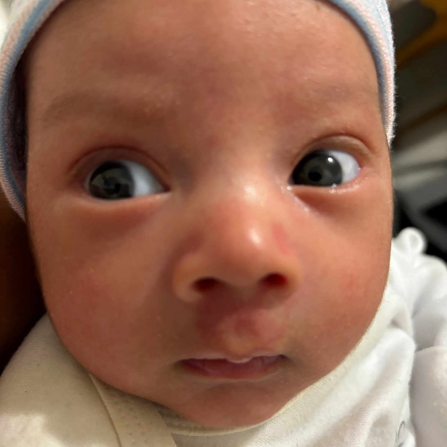 Saúl is registered to the contest to win money with this photo: apparel, baby, child, closeup, clothing, cute, expression, eyes, face, hat, headwear, indoors, infant, newborn, person, portrait, skin, soft, white, young