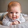 baby, infant, child, portrait, smiling, lying_down, tummy_time, face, eyes, hands, long_sleeves, striped_clothing, bed, blanket, bedroom, indoors, soft_lighting, close_up, photography, happy