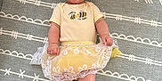 Adalynn joined the competition — help win amazing prizes! baby, smiling, child, yellow_outfit, headband, bow, lying_down, patterned_mat, happy, cute, infant, clothing, indoors, toddler, legs, hands, face, baby_girl, white_lace, joy