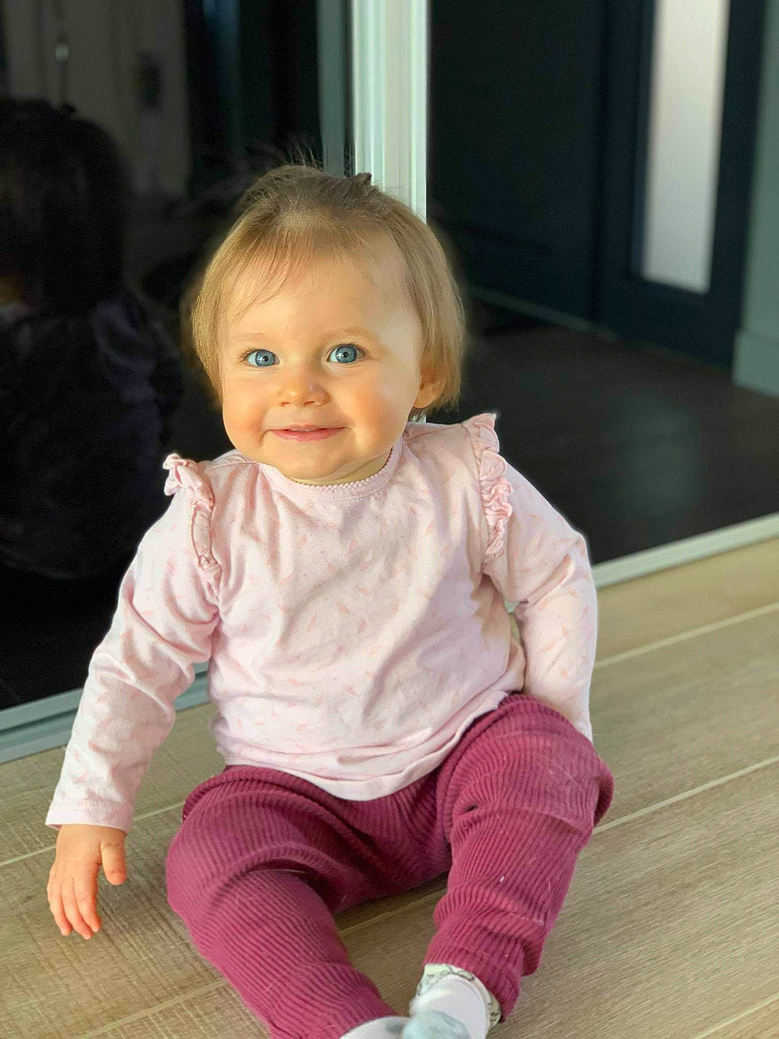 Alicia a rejoint le concours — aidez-le/la à gagner de superbes lots ! baby, baby_toddler_clothing, cheek, child, eye, face, floor, flooring, fun, hair, happy, hardwood, head, iris, joy, magenta, person, skin, sleeve, smile