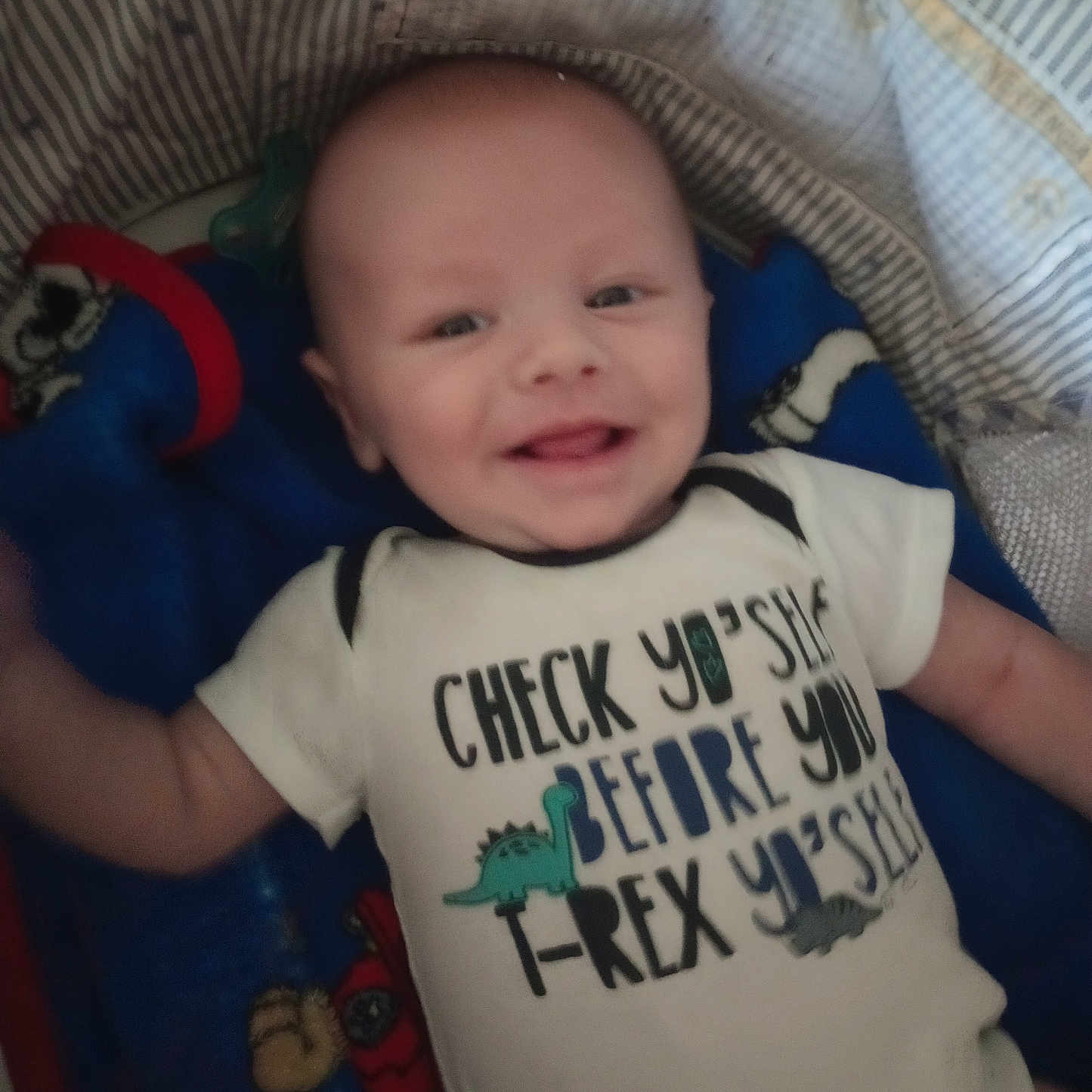 Zachary is registered to the contest to win money with this photo: baby, bed, blanket, clothing, cradle, crib, cushion, face, furniture, happy, head, homedecor, infantbed, newborn, person, photography, portrait, shirt, smile, t_shirt