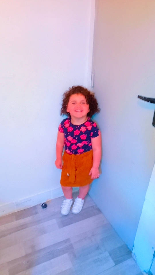Janna participe au concours pour gagner de l'argent avec cette photo : baby_toddler_clothing, child, door, electric_blue, floor, flooring, fun, hardwood, human_leg, joy, knee, magenta, pattern, peach, person, room, sleeve, smile, stairs, t_shirt