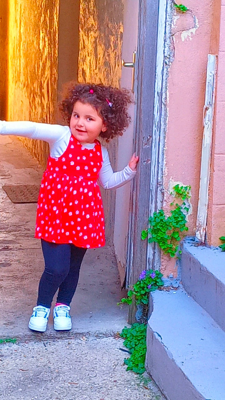 Janna a rejoint le concours — aidez-le/la à gagner de superbes lots ! azure, baby_toddler_clothing, child, dress, electric_blue, facial_expression, happy, human_leg, joy, magenta, pattern, person, pink, plant, sleeve, textile, tints_and_shades, toddler, waist, wall