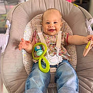 Rose a rejoint le concours — aidez-le/la à gagner de superbes lots ! baby, child, smiling, happy, sitting, baby_seat, toy, colorful_toy, clothing, jeans, floral_top, indoor, person, cute, infant, face, hands, footwear, strap, comfort