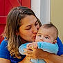 woman, baby, kiss, blue_clothing, red_door, emotional, love, affection, portrait, closeup, face, skin, hair, hands, indoor, family, tender, candid, person, child