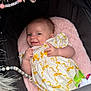 Harlow Rivah is registered to the contest to win money with this photo: baby, infant, smile, stroller, pink, cushion, clothing, white, yellow_bows, hand, face, person, cute, toy, beads, soft, cozy, child, lying, playful