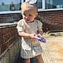 Paisley joined the competition — help win amazing prizes! toddler, child, outdoor, sunlight, bow, toy, dress, purse, socks, shoes, curious, standing, concrete, brick_wall, accessory, fashion, young_child, portrait, daylight, casual