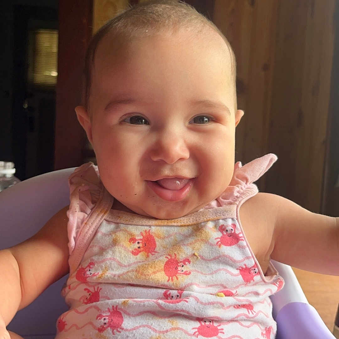 Olivia joined the competition — help win amazing prizes! baby, bodypart, brush, clothing, cutlery, device, face, finger, furniture, hand, happy, head, laughing, person, photography, portrait, sitting, smile, spoon, tool