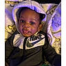 baby, child, hoodie, nike, blanket, smile, tongue_out, cute, infant, clothing, indoors, portrait, happy, cozy, soft, young_child, face, sitting, baby_garment, casual