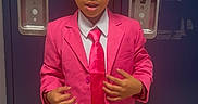 Messiah Harris joined the competition — help win amazing prizes! background, boy, child, clothing, curly_hair, expression, fashion, formal_wear, hands, indoor, locker, person, pink_suit, portrait, school, serious, standing, suit, tie, young