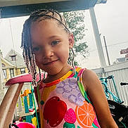 Zahra Harris joined the competition — help win amazing prizes! beads, braids, child, colorful_dress, cute, daylight, fence, fruit_pattern, girl, happy, house, outdoor, play, porch, portrait, smile, summer, toys, tree, young