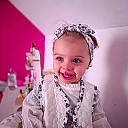 Kécya a rejoint le concours — aidez-le/la à gagner de superbes lots ! toddler, child, smiling, headband, vest, white_clothing, blue_eyes, indoor, portrait, happy, cute, baby, fashion, blurry_background, magenta_wall, person, face, apparel, female, infant