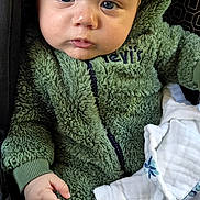 Jeremias joined the competition — help win amazing prizes! baby, infant, child, portrait, car_seat, seated, green_jacket, fleece, blanket, white_clothing, blue_eyes, face, eyes, short_hair, serious_expression, indoor, travel, automobile, close_up, photography