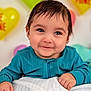 baby, child, smile, face, hands, blue_clothing, blanket, balloons, heart_shaped, valentine, cute, portrait, indoor, happy, infant, young_child, celebration, colorful, background, warm_lighting